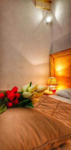 a bed with red and white flowers on it at Casina Raho B&B in Nardò