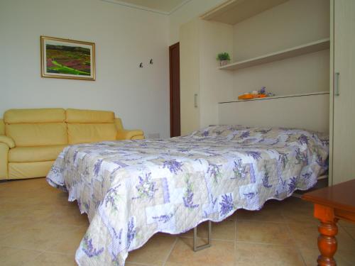 a bedroom with a bed and a couch at La Vigna Del Parroco in Verduno