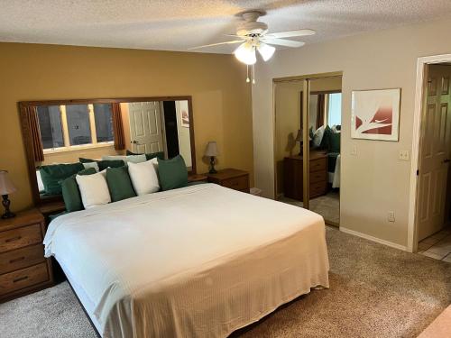 a bedroom with a large bed and a ceiling fan at Greens One Vacation Home 3 in Bella Vista