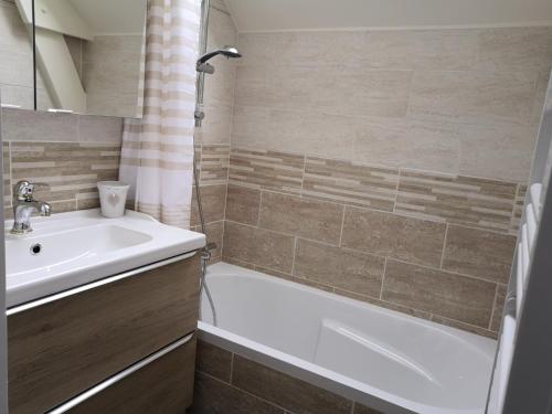 a bathroom with a tub and a sink and a bath tub at Appartement fonctionnel et chaleureux proche mer in Le Croisic