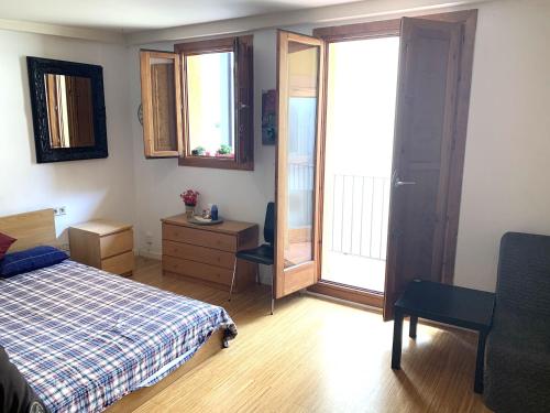 een slaapkamer met een bed, een bureau en een raam bij Apartment next to Ramblas in Barcelona