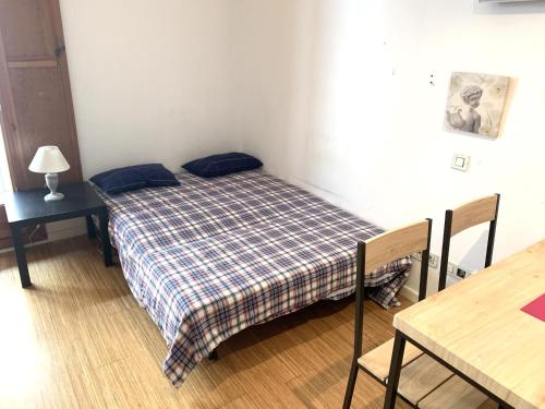 een kleine slaapkamer met een bed en een tafel bij Apartment next to Ramblas in Barcelona