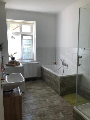 a bathroom with a bath tub and a sink at Altes Schulhaus Mutschelbach in Karlsbad