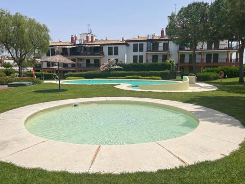 una piscina de agua en un patio con edificios al fondo en Ayamonte - Vista Esuri Golf and Beach en Huelva