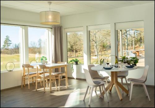 a dining room with tables and chairs and windows at Varbergs GK Västra Hotell in Tvååker