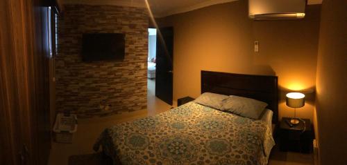 1 dormitorio con cama y pared de ladrillo en Navona Towers Amplio Apart, Dos Noches minimo, para 4 personas lo mejor de Panamá en Panamá