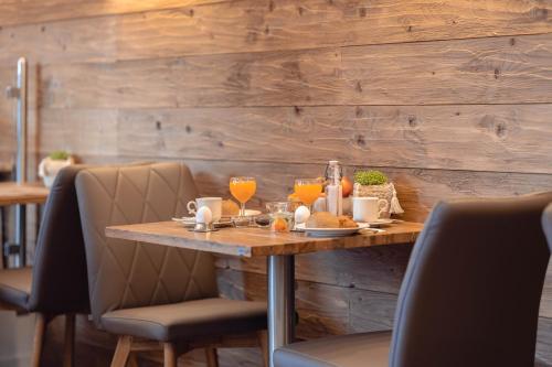 a wooden table with food and drinks on it at Wellness Pension am Rain in Winden im Elztal