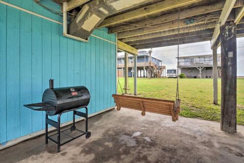 a barbecue grill and a bench on a porch at Walk to Ocean Coastal Surfside Beach Bungalow! in Freeport