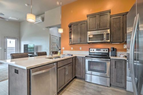 a kitchen with stainless steel appliances and wooden cabinets at Modern Coeur dAlene Home Near Trails and River! in Coeur d'Alene