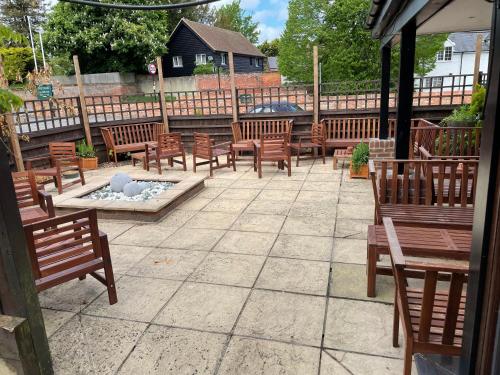 a patio with wooden benches and a fire pit at The Swan Inn in East Ilsley