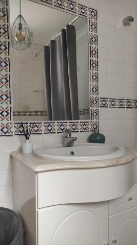 a bathroom with a sink and a mirror at Authentic Charm Soltroia in Troia