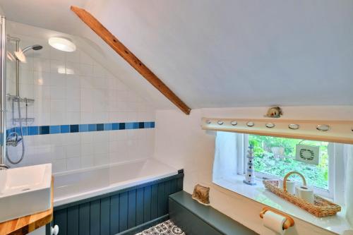 y baño con bañera y lavamanos. en Finest Retreats - Waterside Cottage en Nancledra