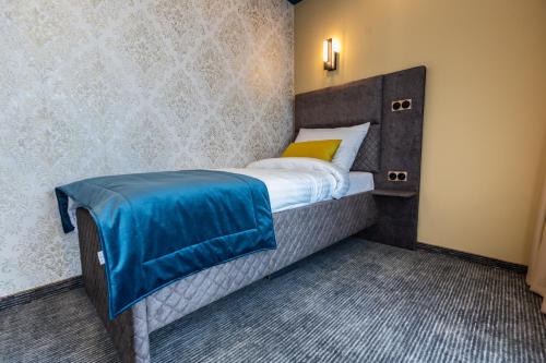 Un dormitorio con una cama con una manta azul. en HOTEL LOBBY en Bihać