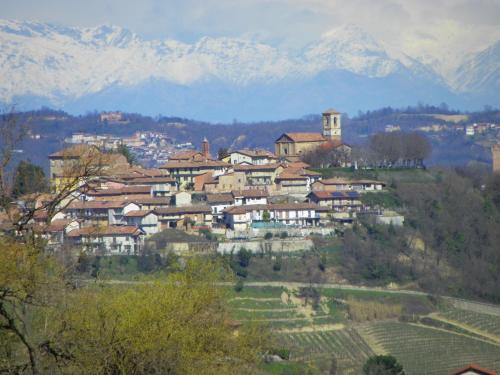 a town on a hill with snowy mountains in the background at La Vigna Del Parroco in Verduno