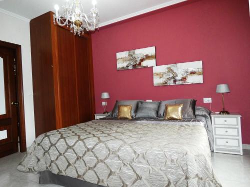 a bedroom with a bed with a red wall at Casa Daniel in Riberas del Sor