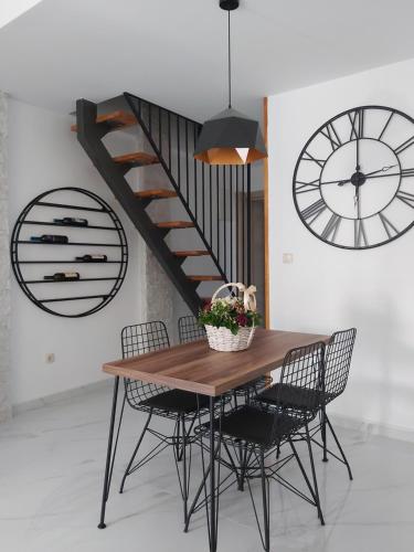 a dining room table with chairs and a staircase at Apartments "4You" in Tivat