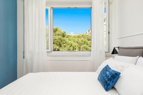 1 dormitorio con cama blanca y ventana en Nelli Rooms Via Veneto en La Spezia
