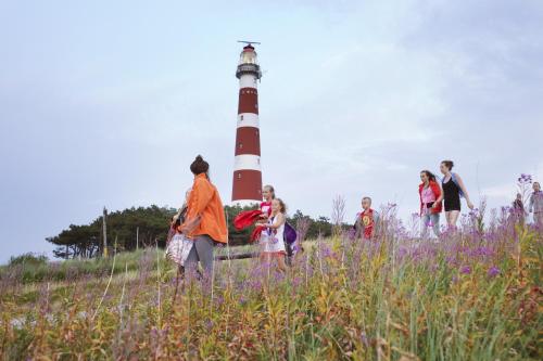 a group of people walking in front of a lighthouse at Sier aan Zee in Hollum