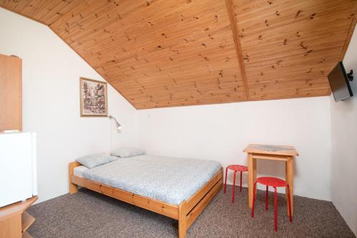 a bedroom with a bed and two red stools at Chyba Wyspa, Ostrowo in Ostrowo