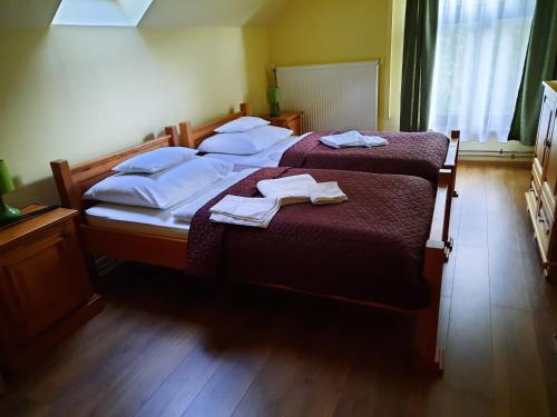 1 dormitorio con 2 camas y toallas. en Ágnes Vendégház, en Tokaj