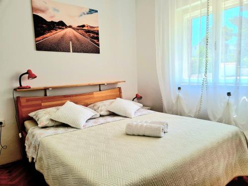 a bed with two pillows on it in a bedroom at APARTMENT IVANA in Brodarica