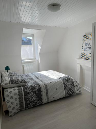 - une chambre blanche avec un lit dans l'établissement Charmante maison de ville avec parking à côté., à Morlaix