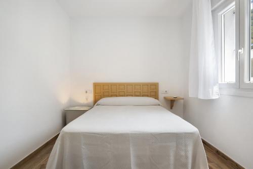 białe łóżko w białym pokoju z oknem w obiekcie Casa de 10 - 5a w mieście Vejer de la Frontera