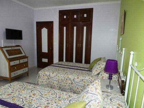 a bedroom with two beds and a table with a lamp at Casa Daniel in Riberas del Sor
