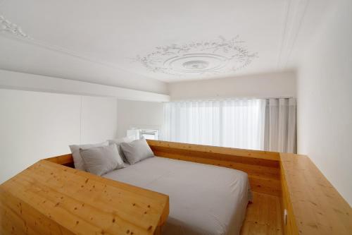 a bed with a wooden frame in a room at Casa Vermelha ii in Faro
