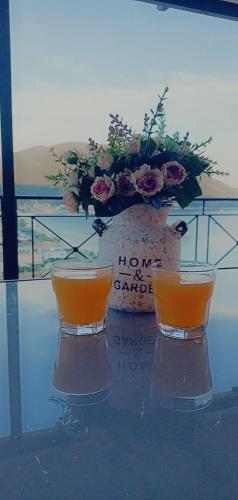 two cups on a glass table with a flower arrangement at Steven in Vasiliki