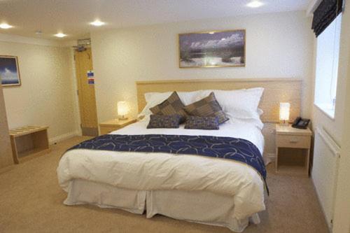 a bedroom with a large bed with two night stands and two lamps at Springfields in Horsham