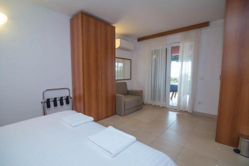 ein Schlafzimmer mit einem Bett und einem Stuhl darin in der Unterkunft Apartman Punta A2+2 in Veli Lošinj