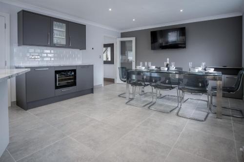 a kitchen with a table and chairs and a fireplace at Gower View - 4 Bedroom Luxurious Holiday Home - Saundersfoot in Saundersfoot