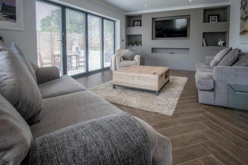 a living room with a couch and a coffee table at Gower View - 4 Bedroom Luxurious Holiday Home - Saundersfoot in Saundersfoot
