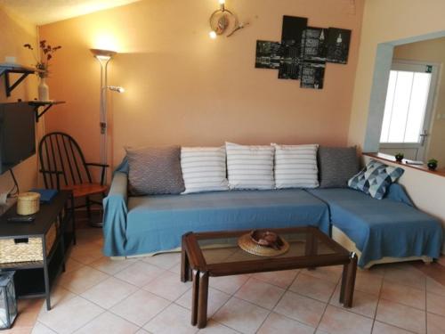 a living room with a blue couch and a table at Apartman studio Dino Klimno in Klimno