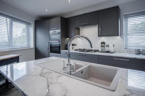 サンダースフットにあるGower View - 4 Bedroom Luxurious Holiday Home - Saundersfootのシンクとカウンタートップのあるキッチン