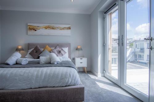 サンダースフットにあるGower View - 4 Bedroom Luxurious Holiday Home - Saundersfootの大きなベッドと大きな窓のある寝室