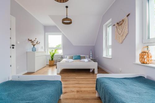 two beds in a room with white walls at Flatbook Apartamenty - Sztutowo Dom Morska in Sztutowo