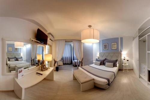 a bedroom with two beds and a living room at Raffaelli Park Hotel in Forte dei Marmi