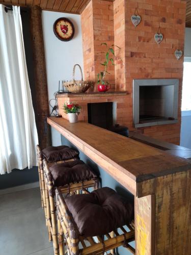 uma cozinha com uma grande mesa de madeira e bancos em Refúgio Altos do Campestre - TURISMO RURAL em Urubici