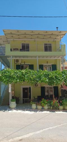 a yellow building with potted plants in front of it at Steven in Vasiliki