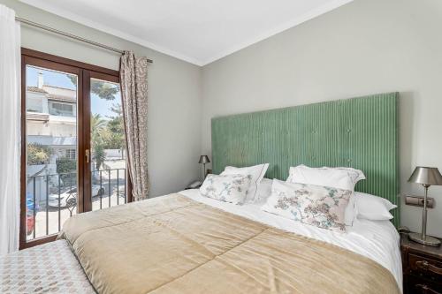 a bedroom with a large bed with a green headboard at All About Puente Romano Penthouse Suite in Marbella