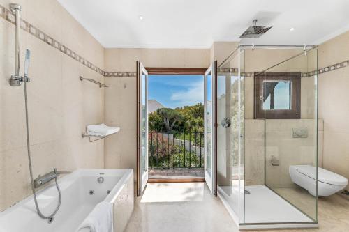 a bathroom with a tub and a shower and a toilet at All About Puente Romano Penthouse Suite in Marbella