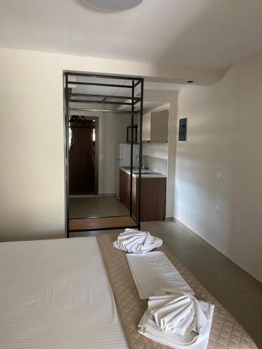 a bedroom with a large white bed and a bathroom at Zinozis Beach Apartments in Vourvourou