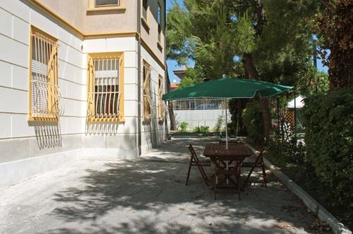 チヴィタノーヴァ・マルケにあるPino Marittimoの隣の緑傘付きテーブル