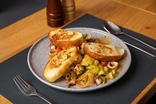 a plate of food with bread and vegetables on a table at Kozjanski dvor in Podčetrtek