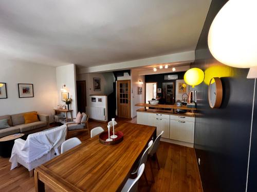 Il comprend une cuisine et un salon avec une table en bois. dans l'établissement Bruyère Blanche Le Touquet Paris Plage, à Le Touquet-Paris-Plage