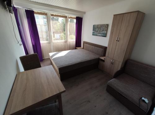 a small room with a bed and a table at OZone Apartman in Siófok