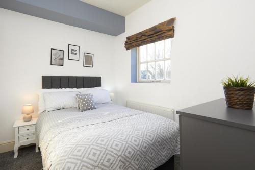 um quarto com uma cama, uma mesa e uma janela em Derby Cathedral Town House - 2 mins walk to city - FREE secure parking em Derby