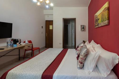 a bedroom with a large bed with a red wall at LA CASA DI MAMMA 'NTO in Castrofilippo